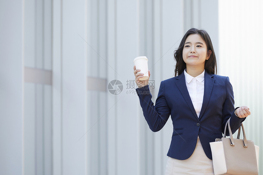 拿着咖啡开心的年轻女子图片