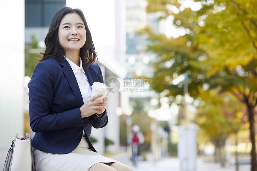 拿着咖啡微笑的年轻女子图片