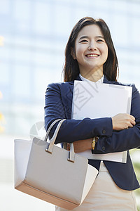 抱着文件微笑的青年女子图片