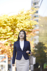 路上穿着职业装行走的女青年图片