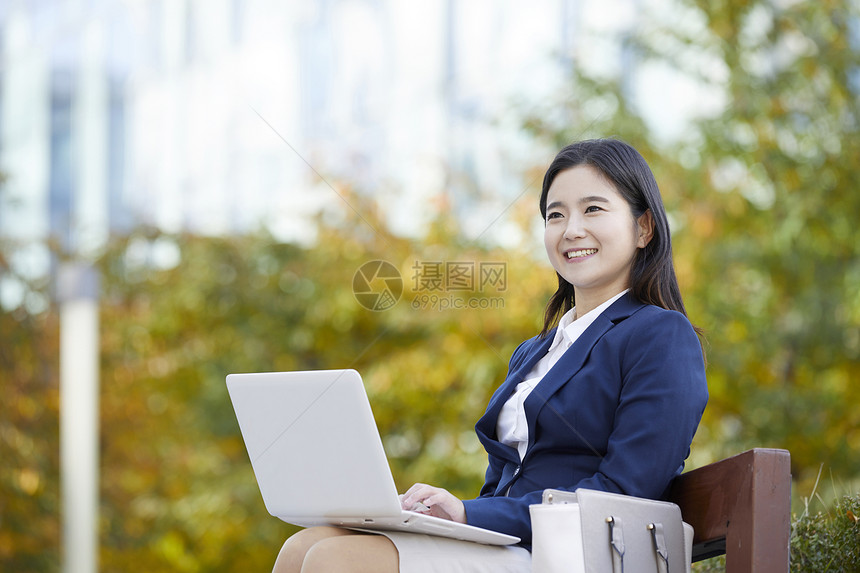 户外使用笔记本电脑的成年女子图片