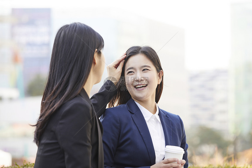 为朋友整理头发的青年女性图片