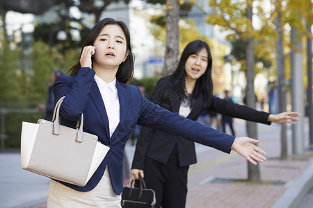 站在路边打着电话拦车的青年女子图片