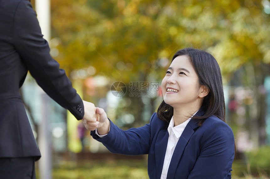 握手微笑的年轻女子图片