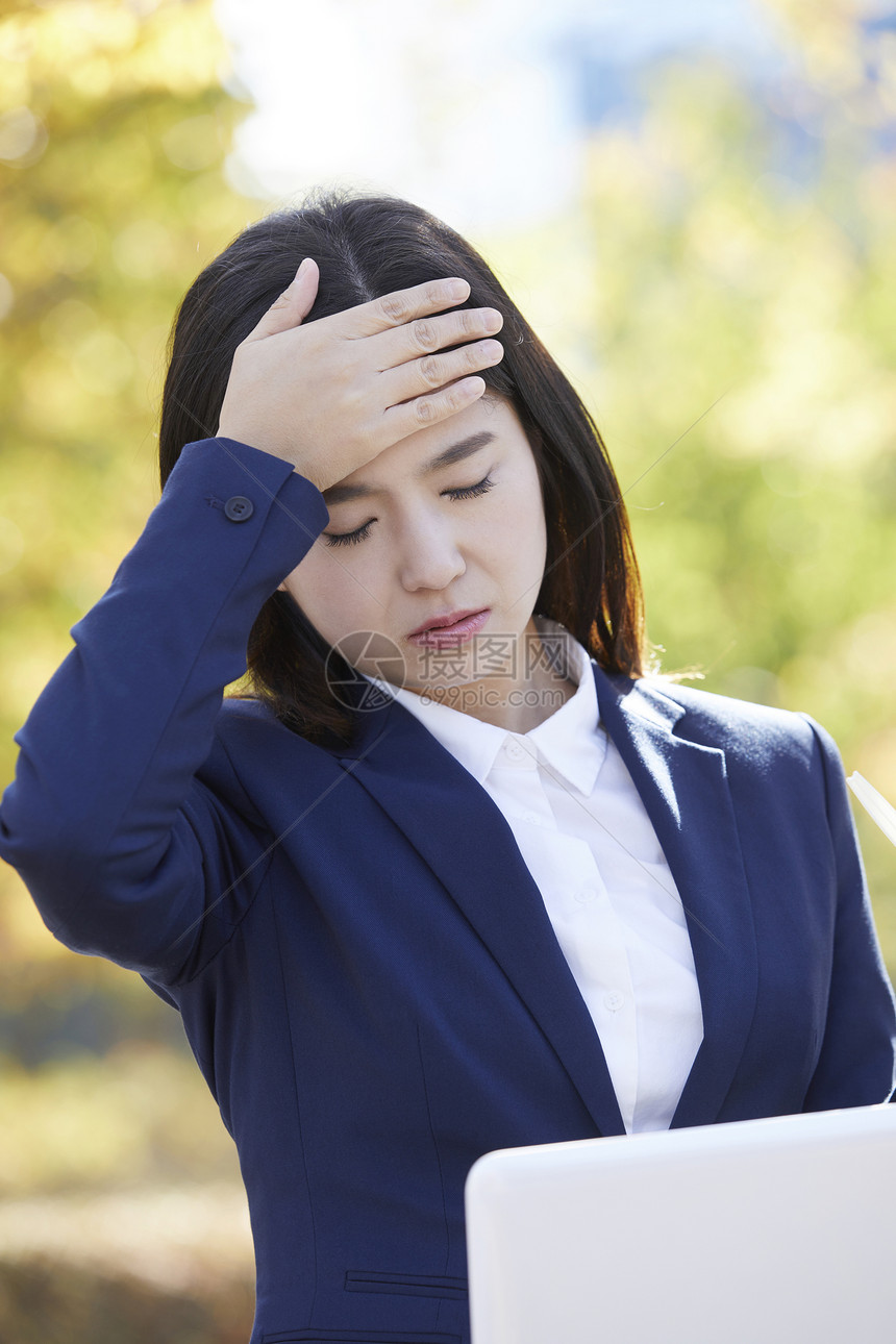 扶着额头疲惫的年轻女子图片