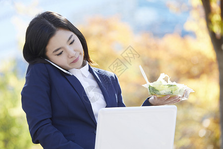 歪头夹住手机打电话的女青年图片