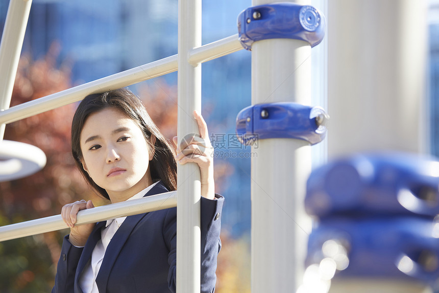 靠在栏杆上忧虑的女青年图片