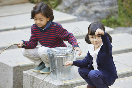 户外两个小孩在河边钓鱼图片