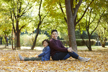 秋天爸爸陪孩子在公园里玩耍图片