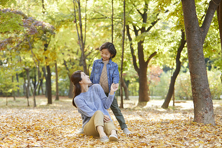 秋天妈妈陪孩子在公园里玩耍图片