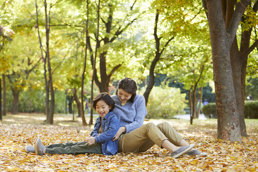 秋天妈妈陪孩子在公园里玩耍图片