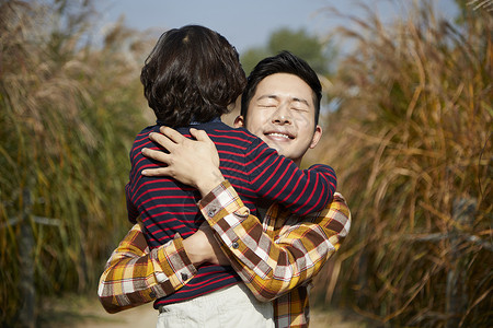 小男孩和爸爸抱在一起图片