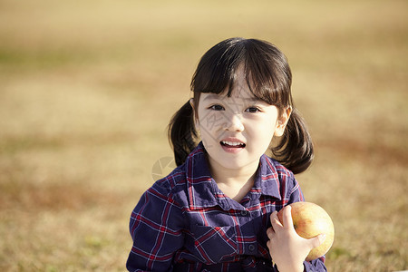 小女孩抱着苹果图片