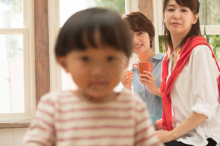 红茶年轻的女孩朋友父母在客厅里放松图片