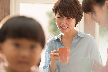 茶高兴美丽放松在客厅的妈妈朋友图片