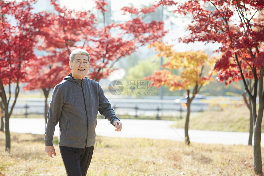 秋天在公园里散步的中年男子图片