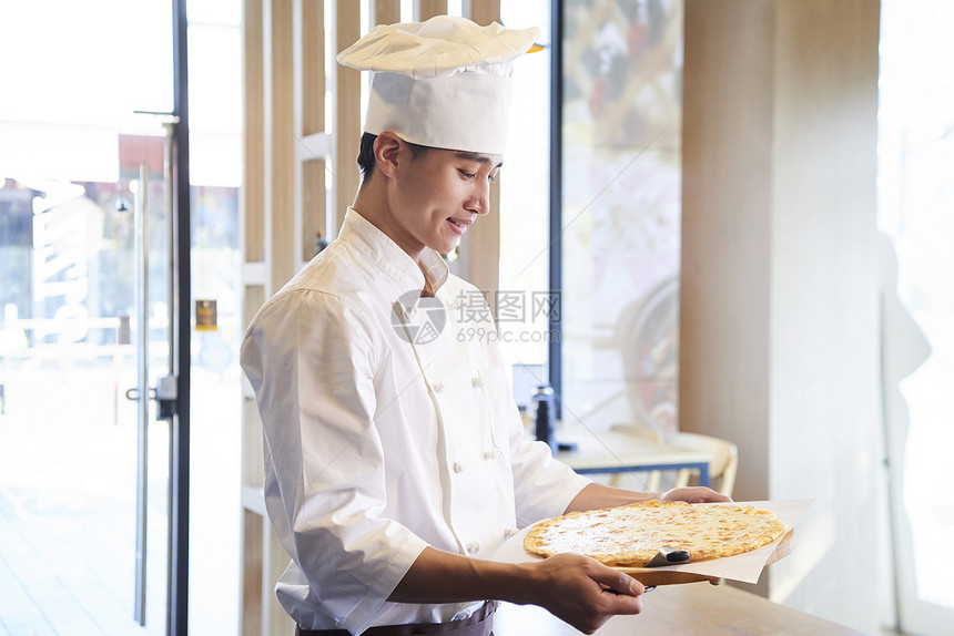 青年面包厨师端着面饼图片