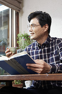 喝茶看书的中年男性图片