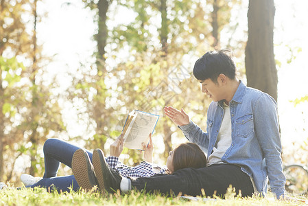 公园草坪上野餐放松的年轻情侣图片