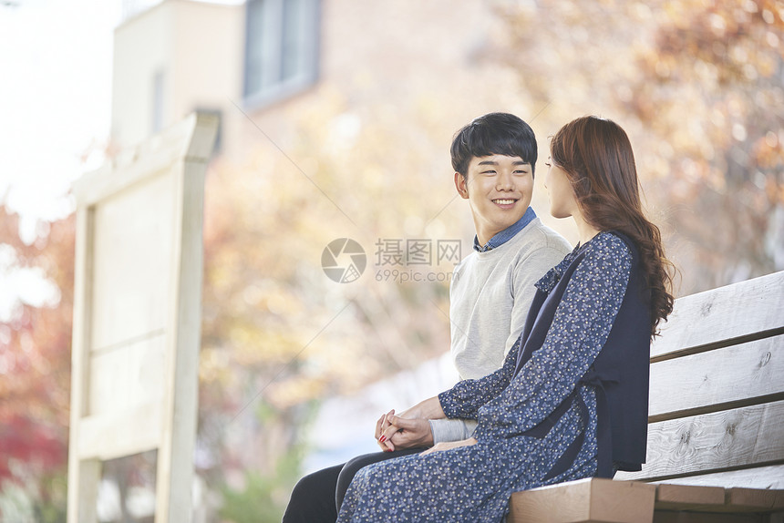 坐在长椅上休息的年轻情侣图片