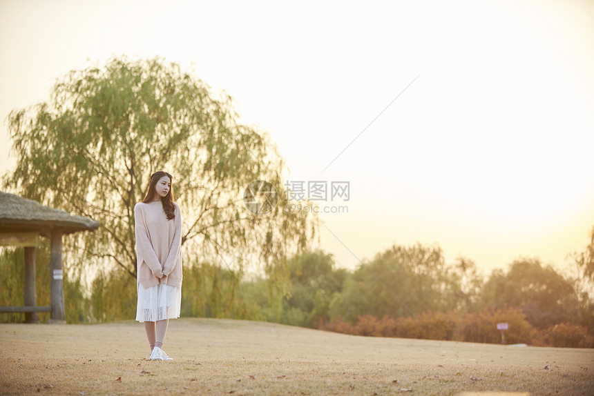 落日草坪上的成年女子图片