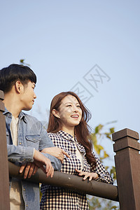 靠在栏杆上看风景的年轻情侣图片