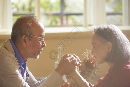 房屋里的老年夫妇紧握双手高清图片