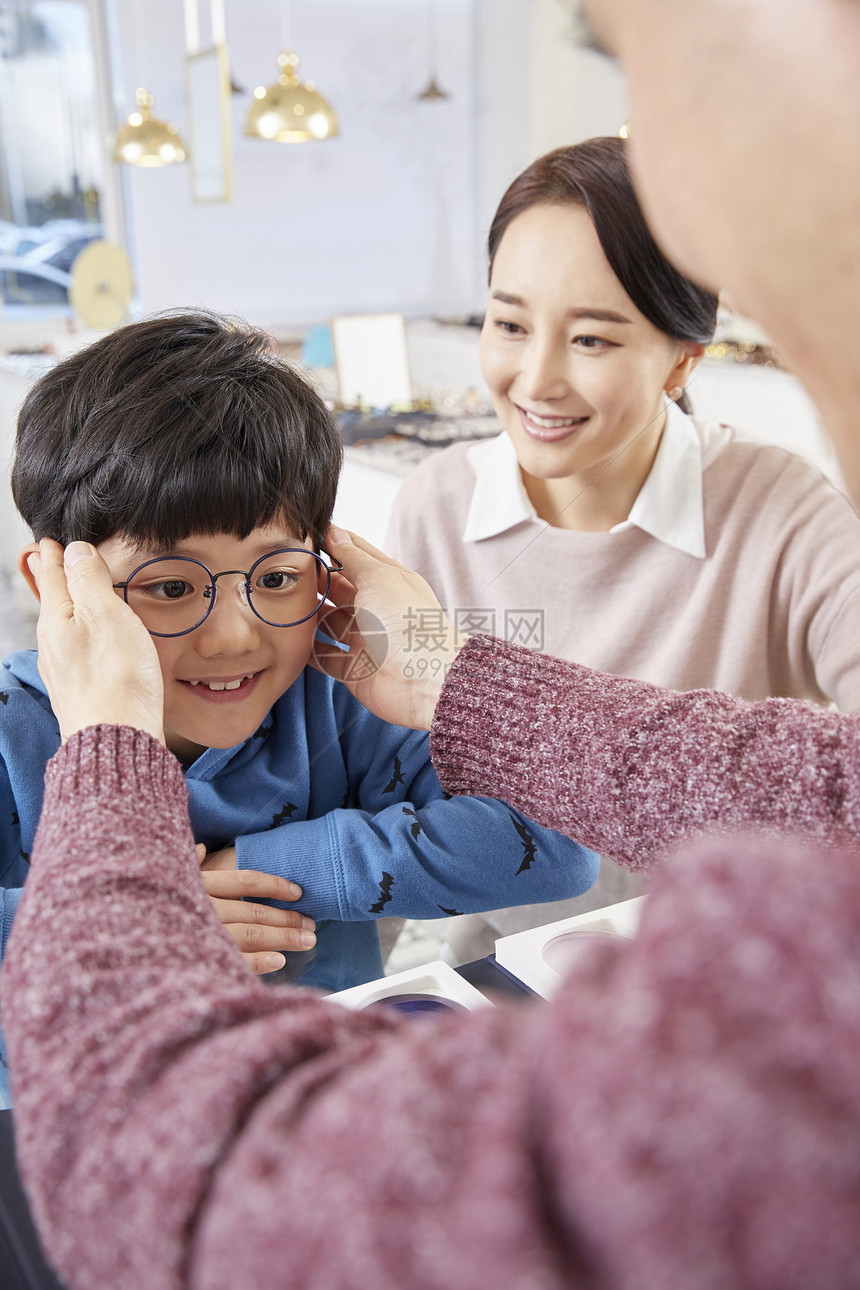 认真在眼镜店工作的成年女性配镜师图片