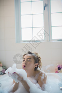 早晨肖像起泡女人享受洗澡时间图片
