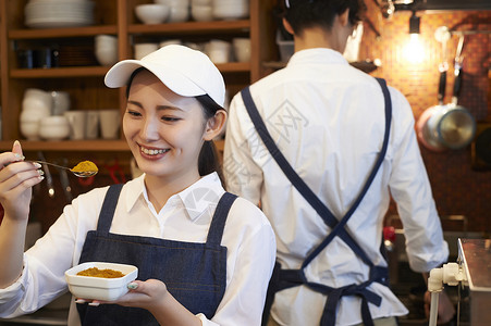 咖哩粉在咖啡店厨房认真工作的年轻男女背景