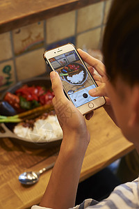 香料餐厅咖喱男子用智能手机拍摄食物背景图片