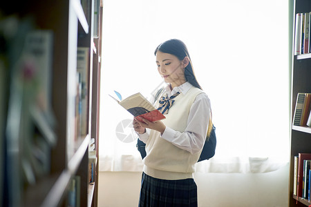 女浏览干净图书馆里的学生图片