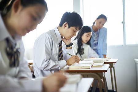 快乐年轻女士们学生在教室里学习图片