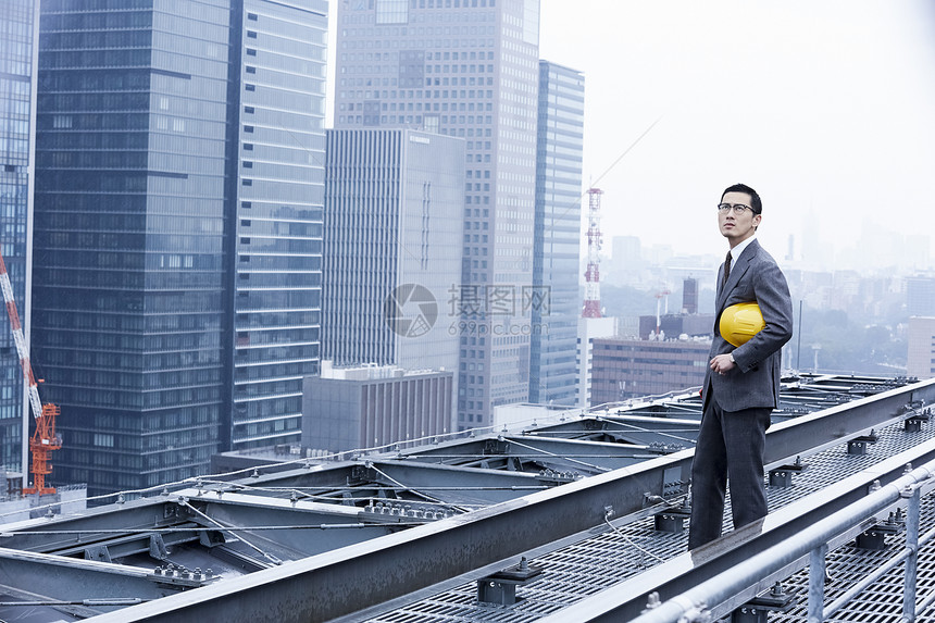 站立在屋顶的建筑商人图片