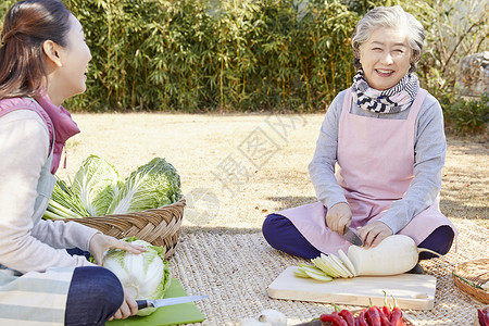 婆婆和媳妇一起准备腌制泡菜的材料背景图片