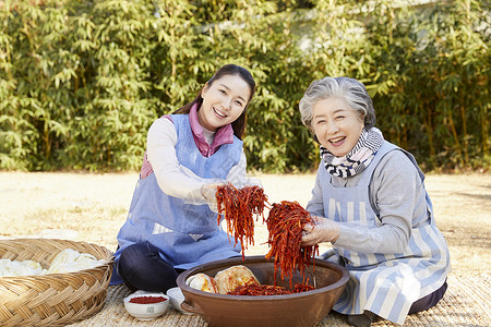 婆婆和媳妇腌制泡菜背景图片