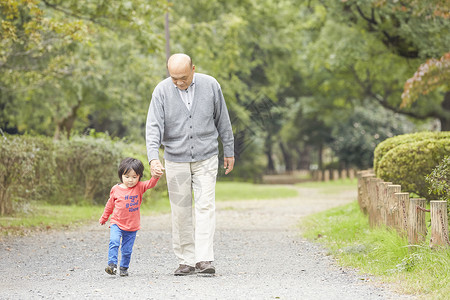 微笑的爷爷和孙子一起玩散步图片