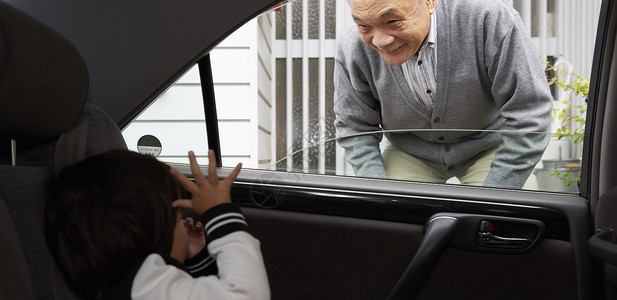 车窗外爷爷看着孙子打招呼高清图片