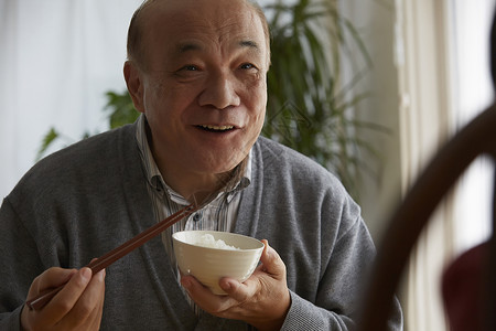 家人吃米饭享用午餐的老人背景