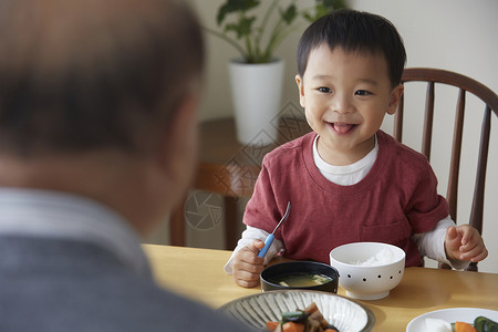 爷爷照顾孙子一起吃饭图片