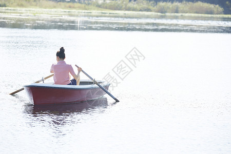 划桨女孩脚踏船单人远足一个独自旅行的女人背景