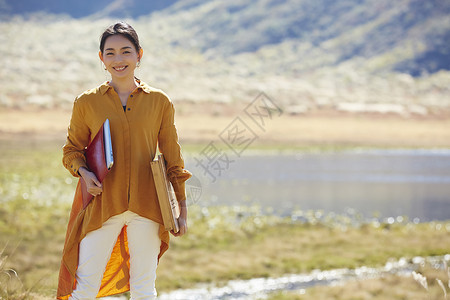 职业旅行女人在草地上工作图片