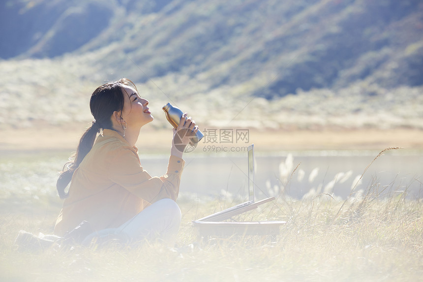 欣赏在草地上工作的女人图片