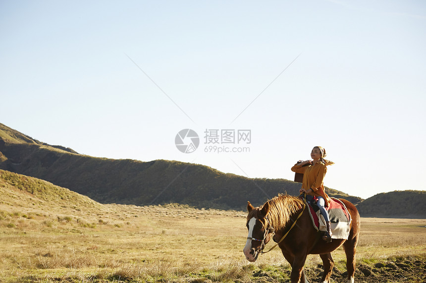 草原上骑马旅游的女人图片