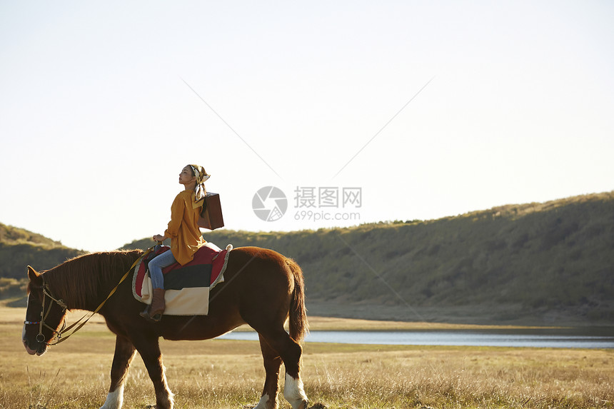 草原上骑马旅游的女人图片