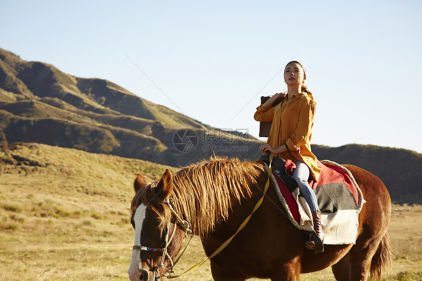 户外草原上骑马旅游的女人图片