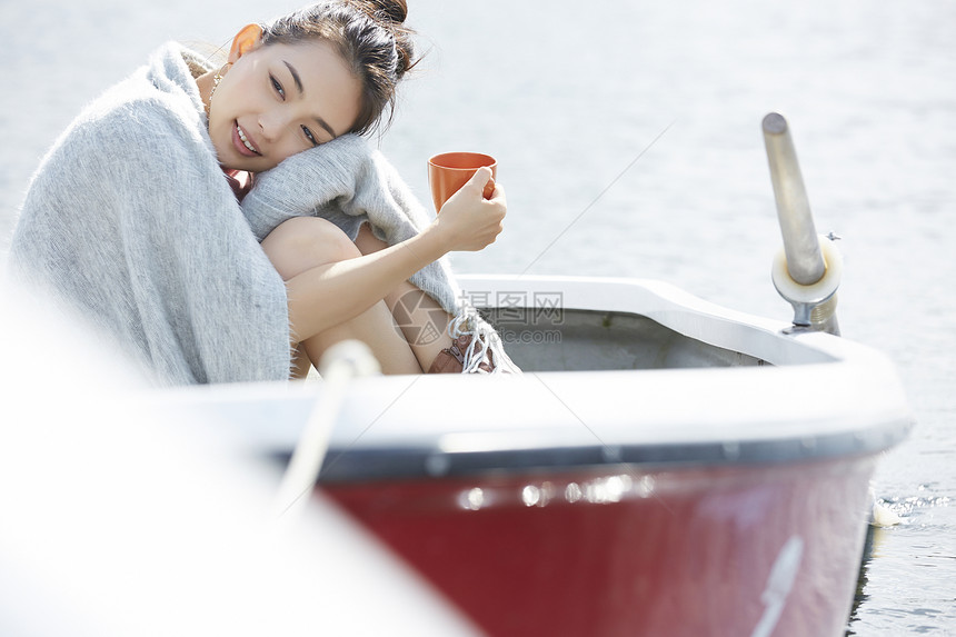 湖泊船上独自旅行的女人用喝咖啡图片