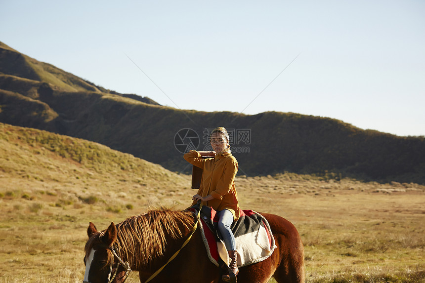 户外草原上骑马旅游的女人图片