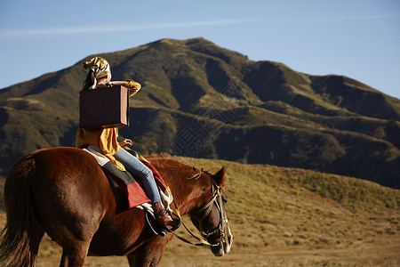 户外草原上骑马旅游的女人图片
