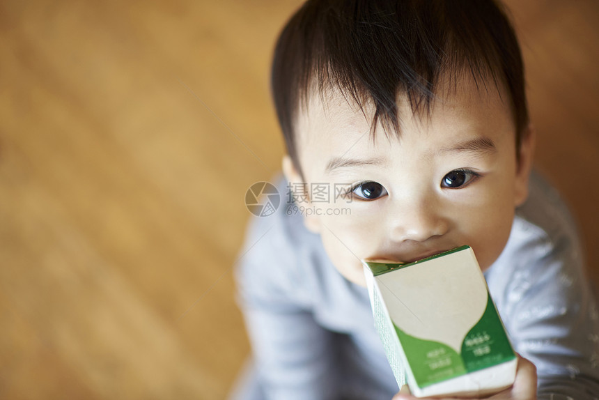 抬头喝牛奶看着镜头的婴儿图片